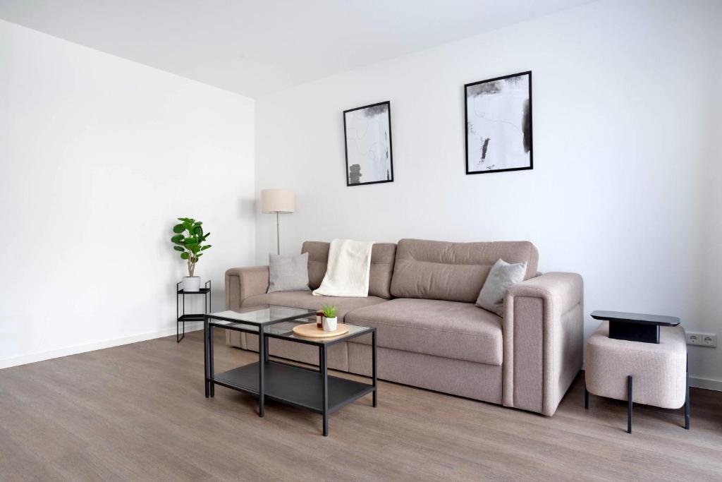 sala de estar con sofá y 2 mesas en Schöne Apartments in Lengerich I home2share en Lengerich
