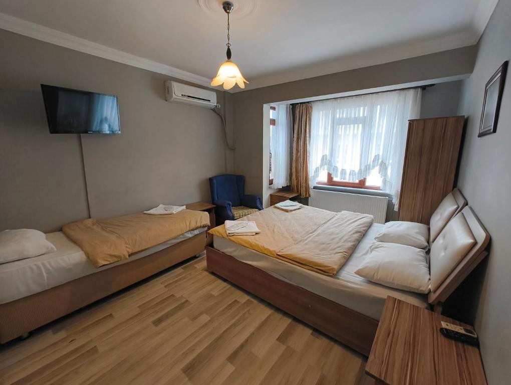 エディルネにあるTac Pansiyonのベッド2台とソファが備わるホテルルームです。