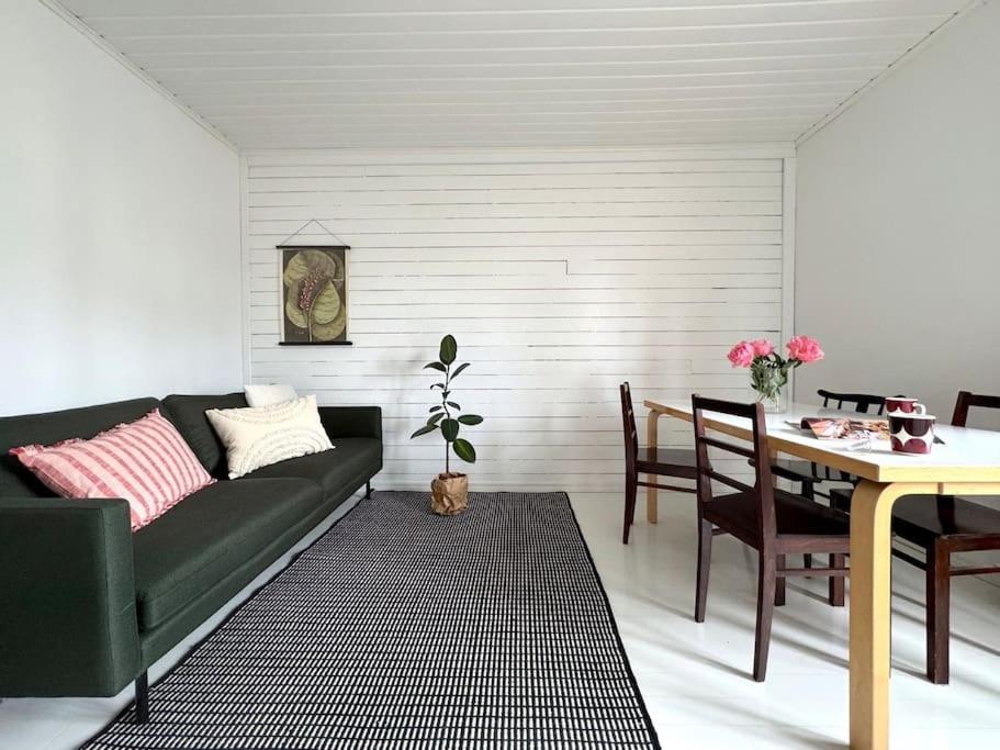 Kaunis kaksio Karjasillalla في أولو: غرفة معيشة مع أريكة خضراء وطاولة