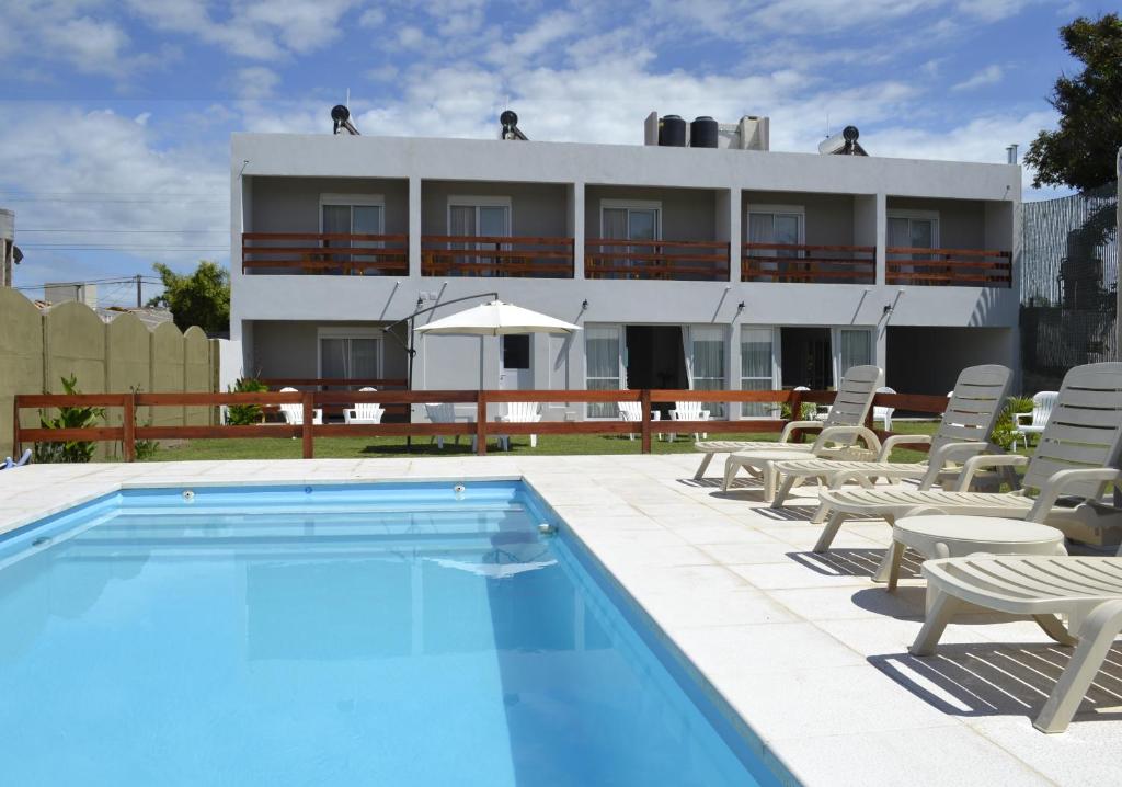 Laguna Suites في ميرامار: فندق فيه مسبح وكراسي ومبنى