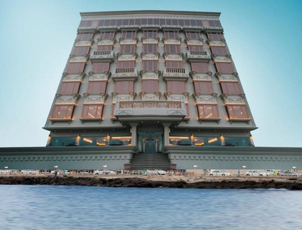 ein großes Gebäude mit einem großen Turm auf dem Wasser in der Unterkunft Al-Borg Hotel in Dschāzān