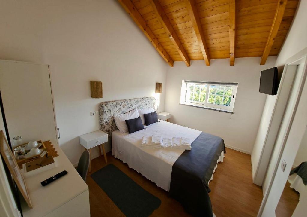 een slaapkamer met een bed en een raam bij Casa do Chafariz - Rooms in Cercal