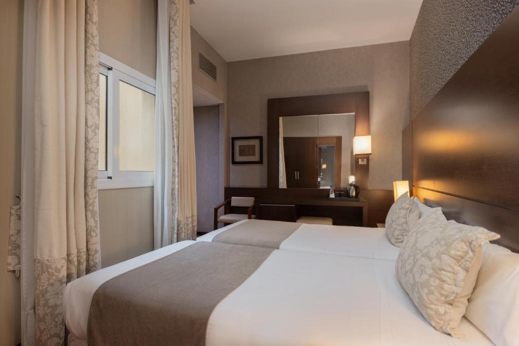 Postel nebo postele na pokoji v ubytování Barcelona Hotel Colonial