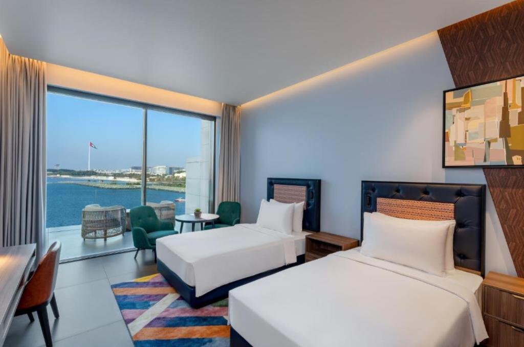 a hotel room with two beds and a large window at Hyatt Centric Jumeirah - Twin Room Sea View - UAE in Dubai