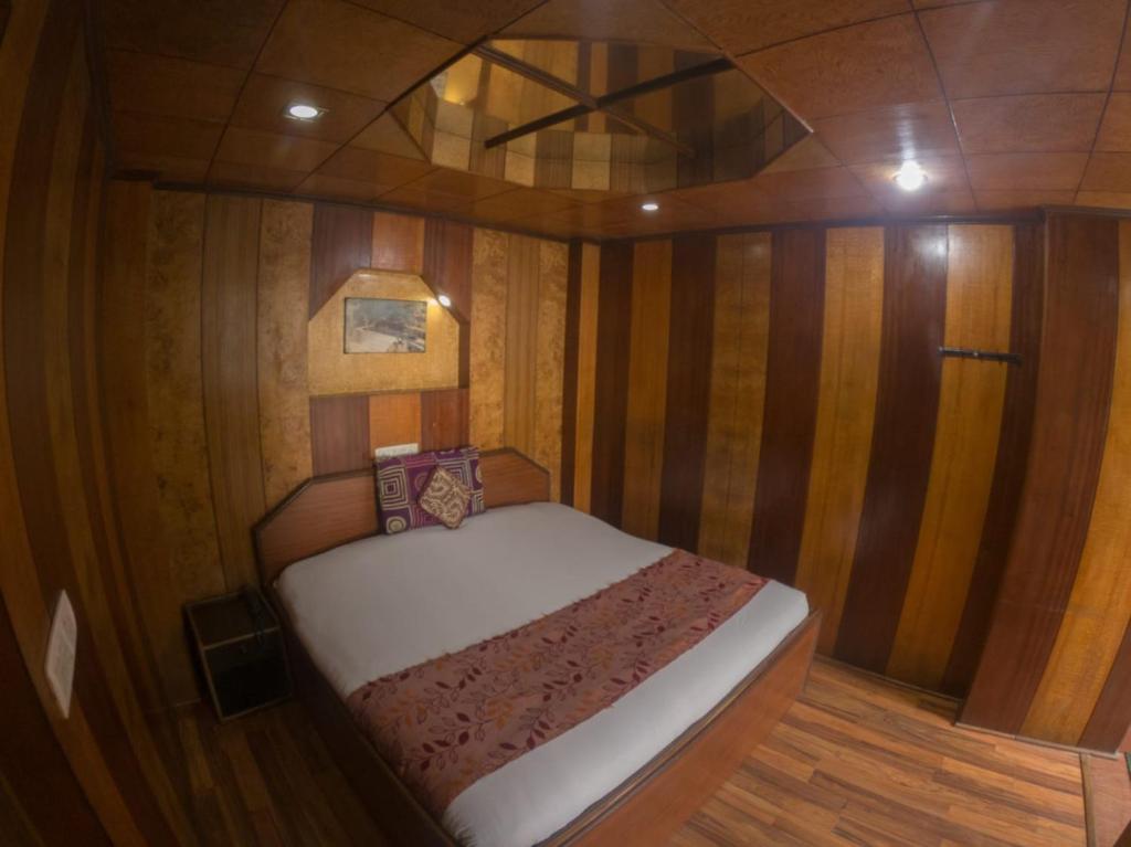 Hotel Broadway Mall Road Darjeeling - Family Joy Vacations & Best Location في دارجيلنغ: غرفة صغيرة مع سرير في قارب