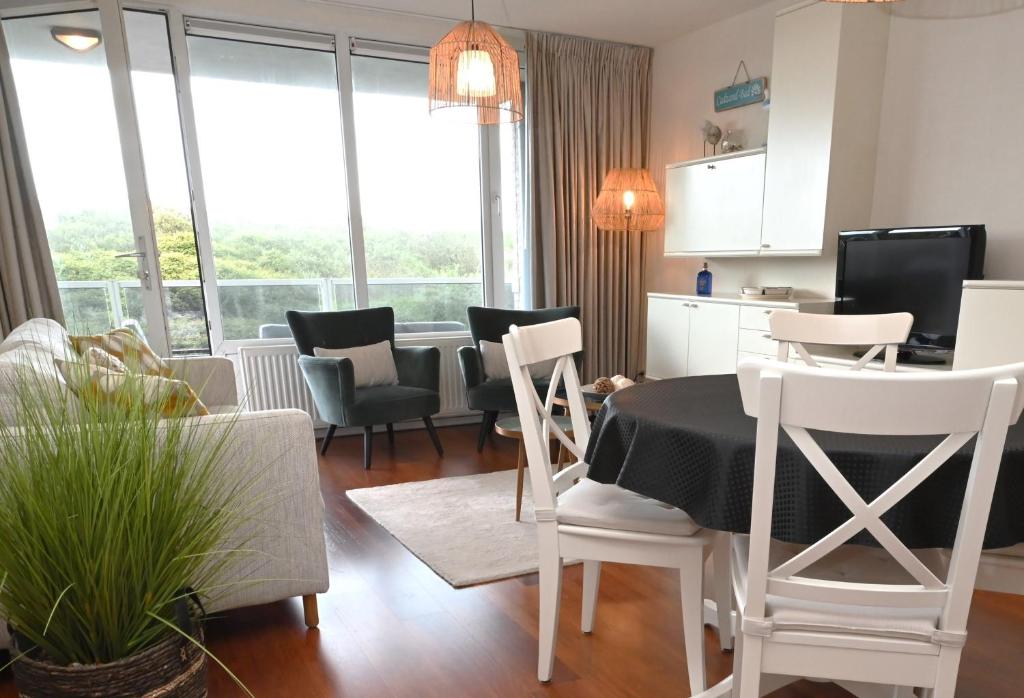 een keuken en een woonkamer met een tafel en stoelen bij Fika - Résidence Deurloo 55-10 in Cadzand