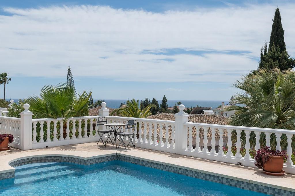 a pool with a white fence and a table on a balcony at Casa Panoramica in Mijas