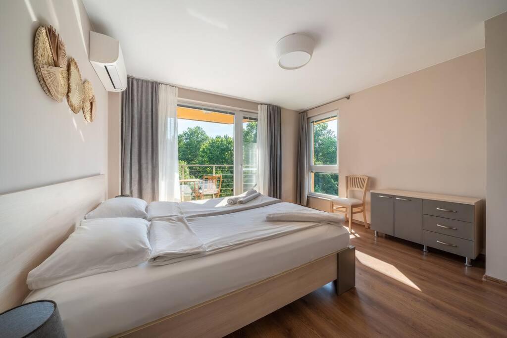 a bedroom with a large bed and a window at Moana Sunset Apartment in Ahtopol