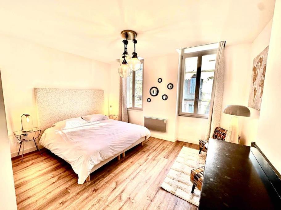 Schlafzimmer mit einem weißen Bett und Holzboden in der Unterkunft Élégance Lauragaise * Wifi * Netflix * Terrasse in Villefranche-de-Lauragais