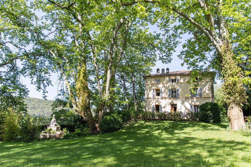 uma casa antiga com um grande quintal com árvores em Château Mentone em Masseboeuf