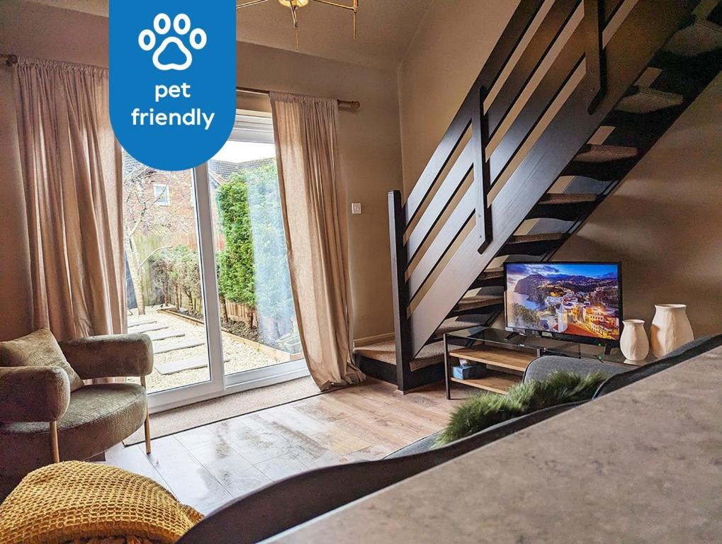 a living room with a tv and a staircase at New, unique, tiny house with garden in Wigston Magna