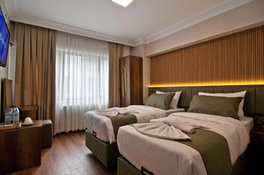 a hotel room with two beds and a window at Aurora Eco Hotel in Istanbul