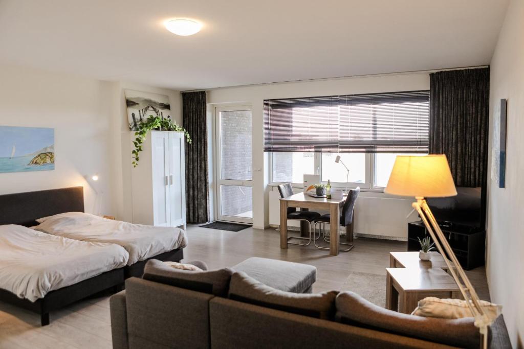 een woonkamer met een bed en een bank bij Strand Appartementen Wemeldinge I Bella Zeelandia in Wemeldinge