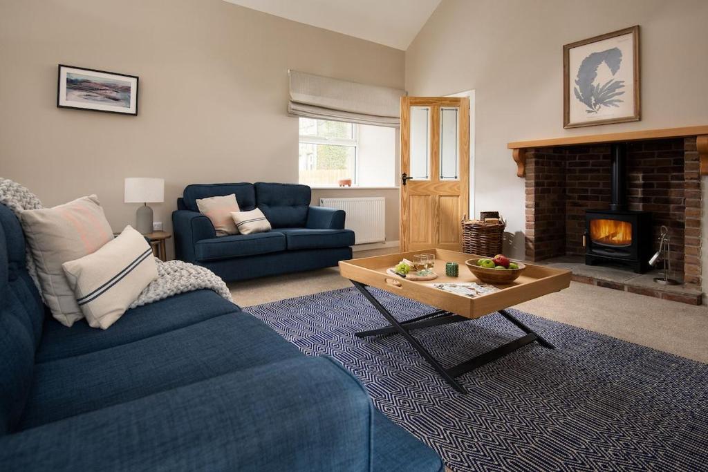 een woonkamer met een blauwe bank en een salontafel bij The Rushes in Bamburgh