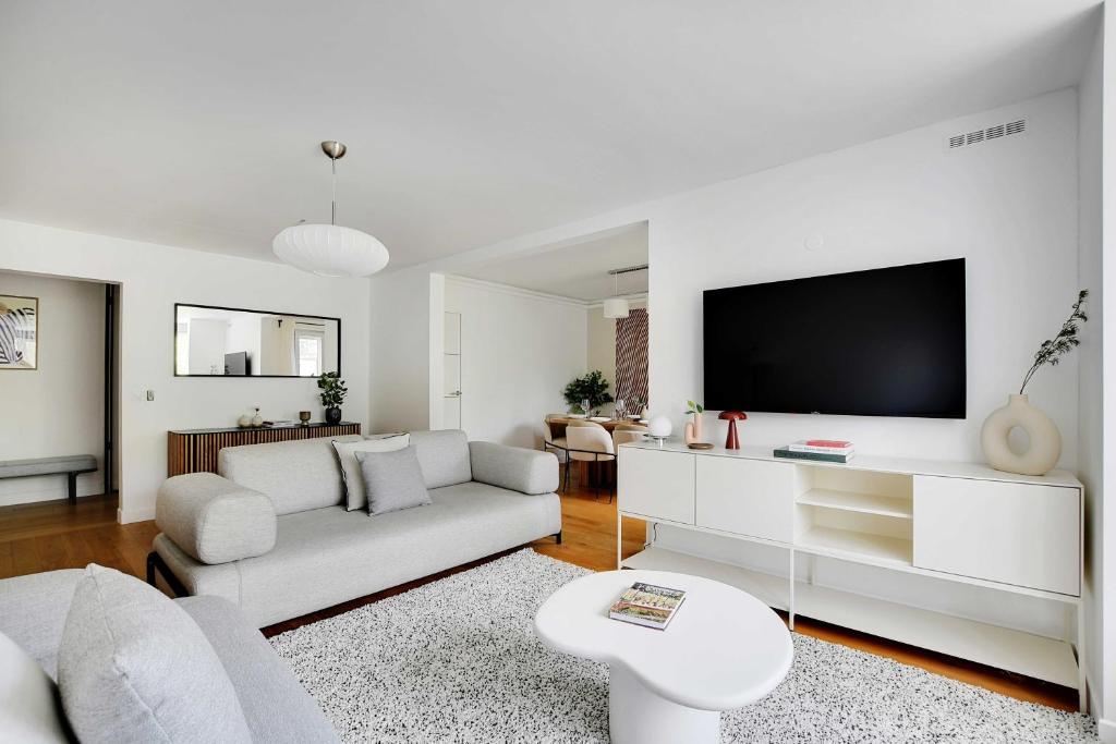 un salon avec un canapé et une télévision à écran plat dans l'établissement Elegant Apartment - Château de Vincennes - 2BR-6P, à Saint-Mandé
