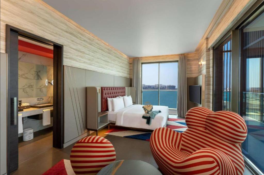 Hyatt Centric Jumeirah Dubai - Deluxe Room - UAE في دبي: غرفه فندقيه بسرير واريكه وكراسي