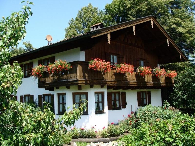 a house with flower boxes on the balcony at Ferienhaus Daxenberger in Bernau am Chiemsee