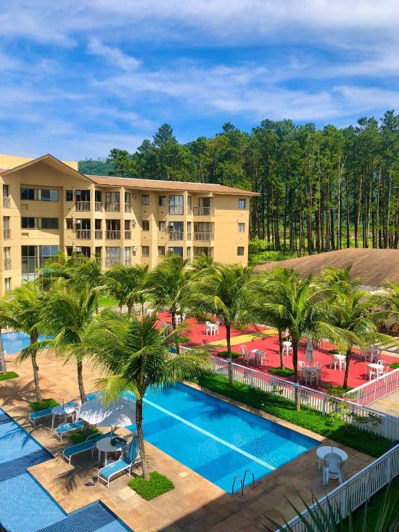 an aerial view of a resort with a pool and palm trees at Condomínio Aldeia dos Reis in Mangaratiba
