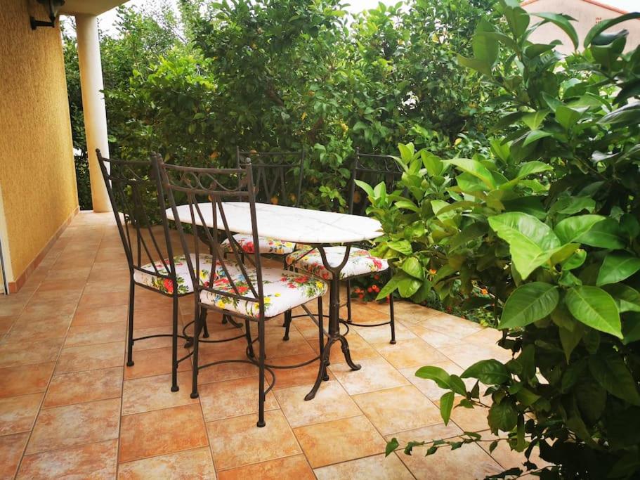 une table et des chaises assises sur une terrasse dans l'établissement Cœur de Millas terrasse, jardin et parking privé, à Millas