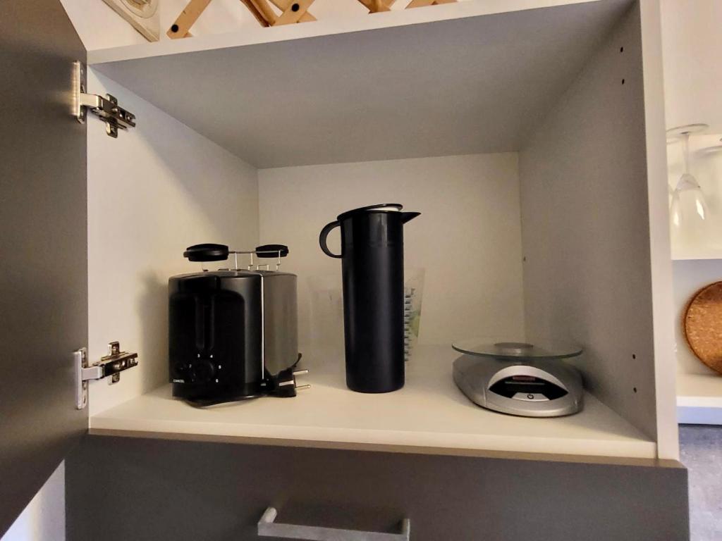 two appliances sitting on a shelf in a kitchen at nJoy! Comfort & Spacious - Balkon - gratis WLAN - perfekt für Work & Travel in Bietigheim-Bissingen
