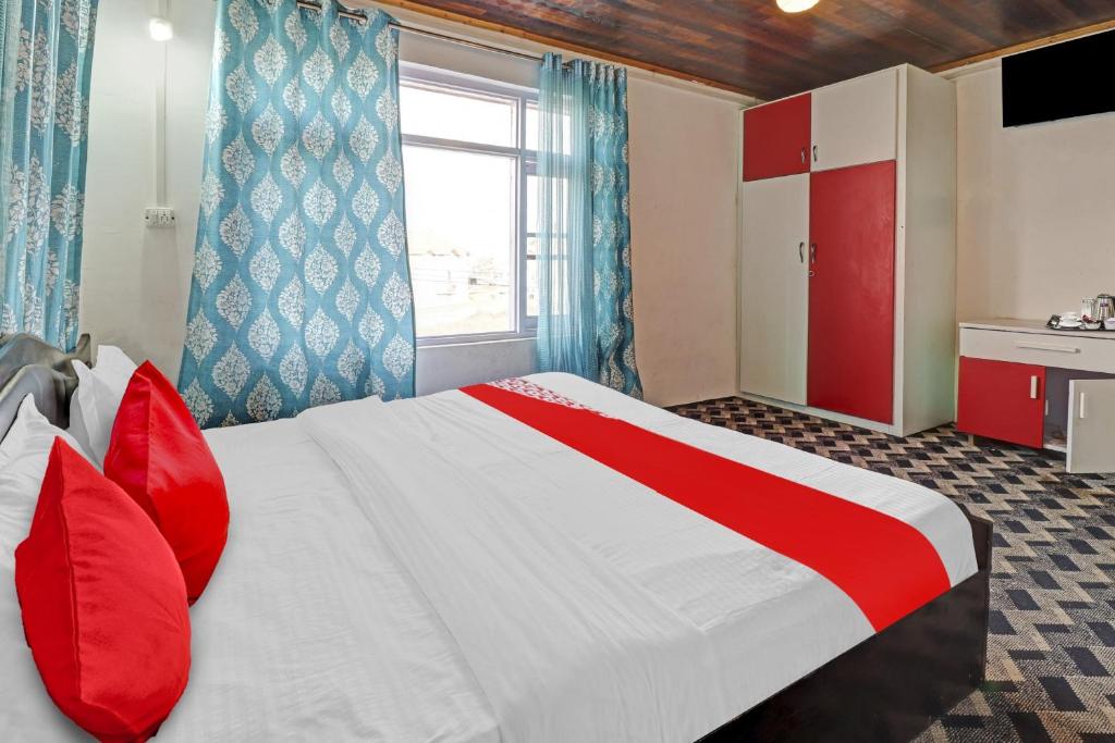 um quarto com uma cama com almofadas vermelhas e uma janela em Eco Rooms em Jawāharnagar