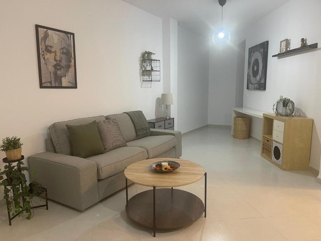 ein Wohnzimmer mit einem Sofa und einem Tisch in der Unterkunft Apartamento Plaza de la Anunciación in Bélmez