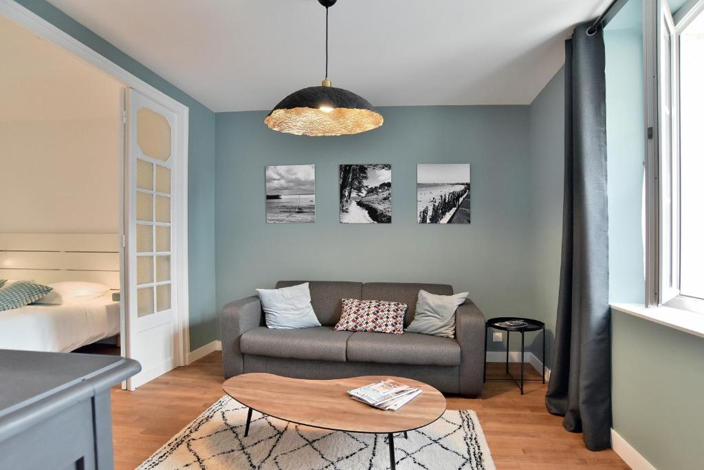 un salon avec un canapé et une table dans l'établissement La Perlezen - Appt pour 4 à 100m de la plage, à Cancale