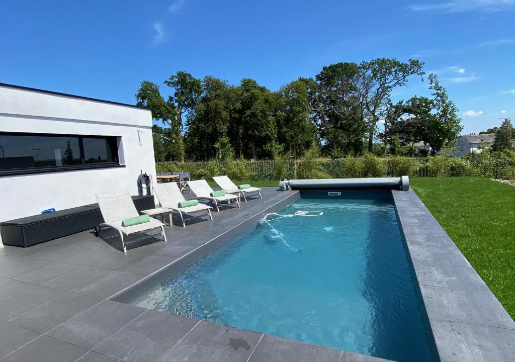une piscine dans une cour avec des chaises autour dans l'établissement Rarissime hébergement avec piscine à Vannes, à 5 minutes du centre, à Vannes