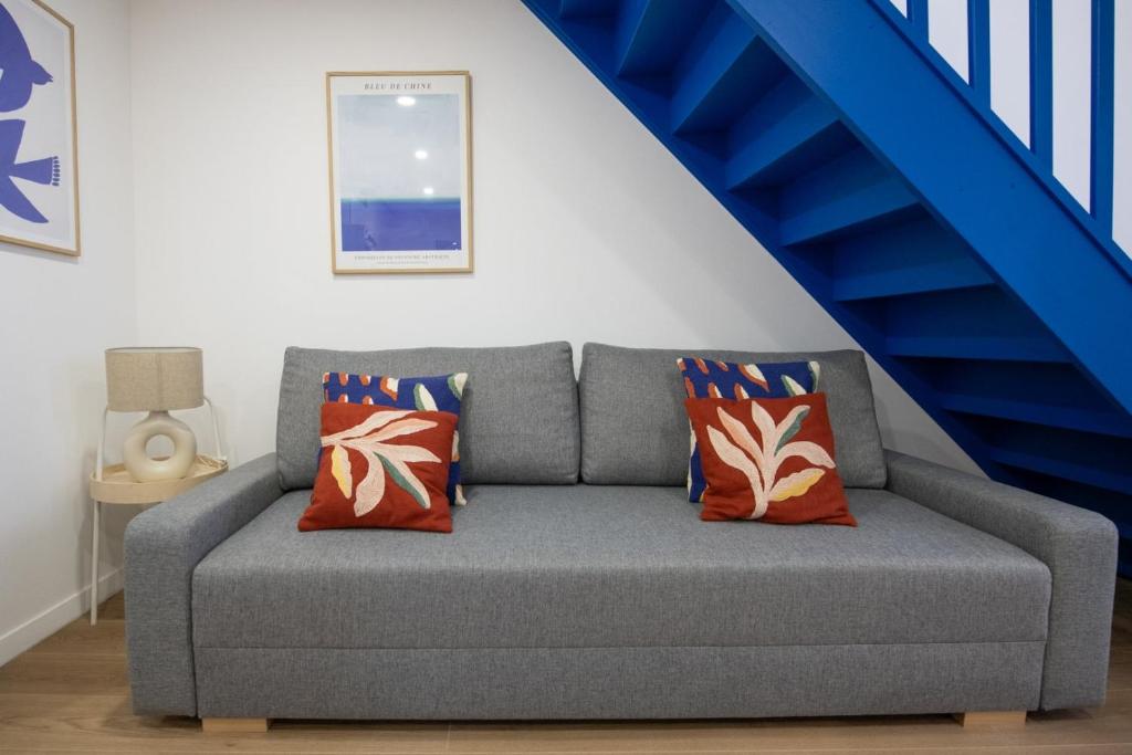 un sofá en una sala de estar con una escalera azul en Casa Azul - Belle maisonnette colorée - Garibaldi, en Lyon