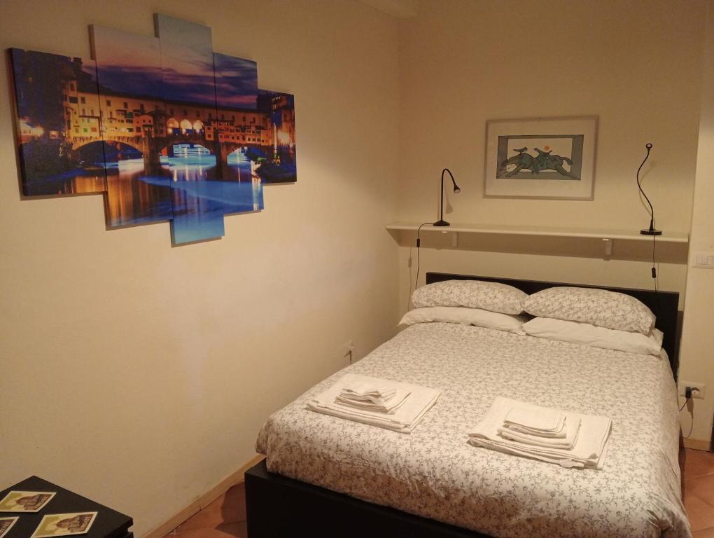 1 dormitorio con 1 cama y una pintura en la pared en Venezia Dodici en Florence