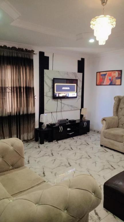 ein Wohnzimmer mit einem Sofa und einem TV in der Unterkunft J Lounge in Ikorodu