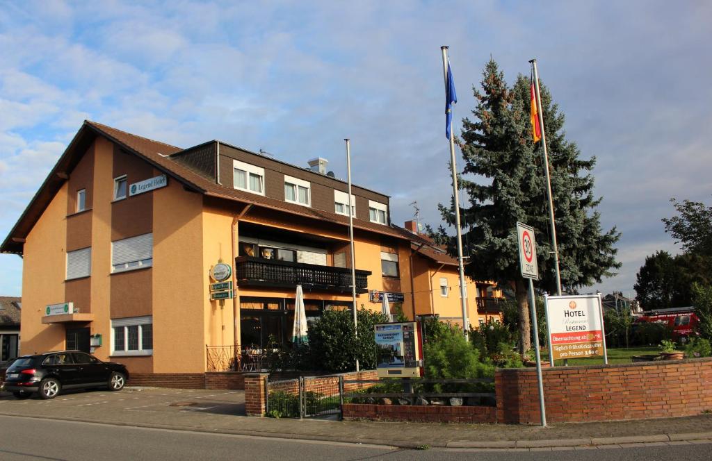 ein Gebäude mit einem davor geparkt in der Unterkunft Legend Hotel in Biebesheim