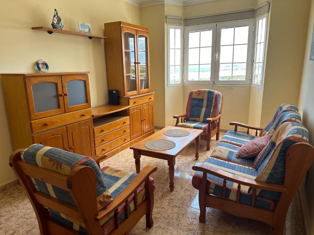 sala de estar con 2 sillas y TV en P&A Apartment en Playa del Burrero