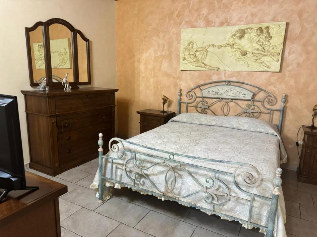 ein Schlafzimmer mit einem Bett, einer Kommode und einem Spiegel in der Unterkunft Desiree Casa Vacanze in Avola
