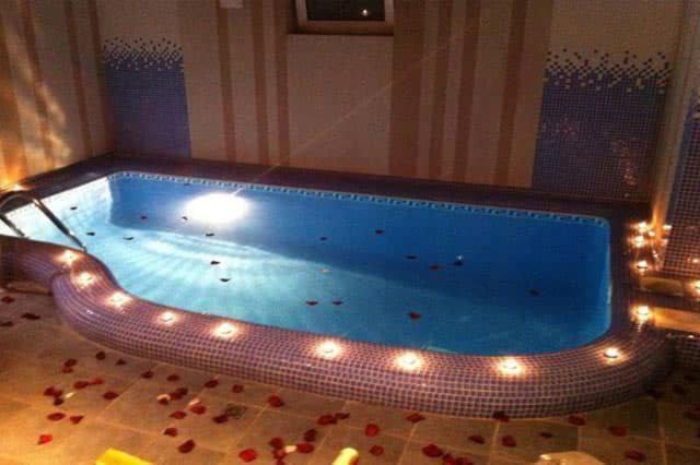 a large swimming pool with lights in a room at Villa Hills in Chimgan