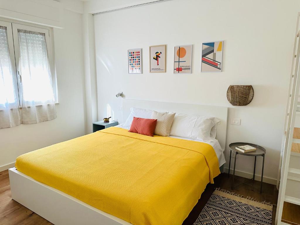 ein Schlafzimmer mit einem Bett mit einer gelben Decke in der Unterkunft Nuovo appartamento Castiglione in Castiglione della Pescaia