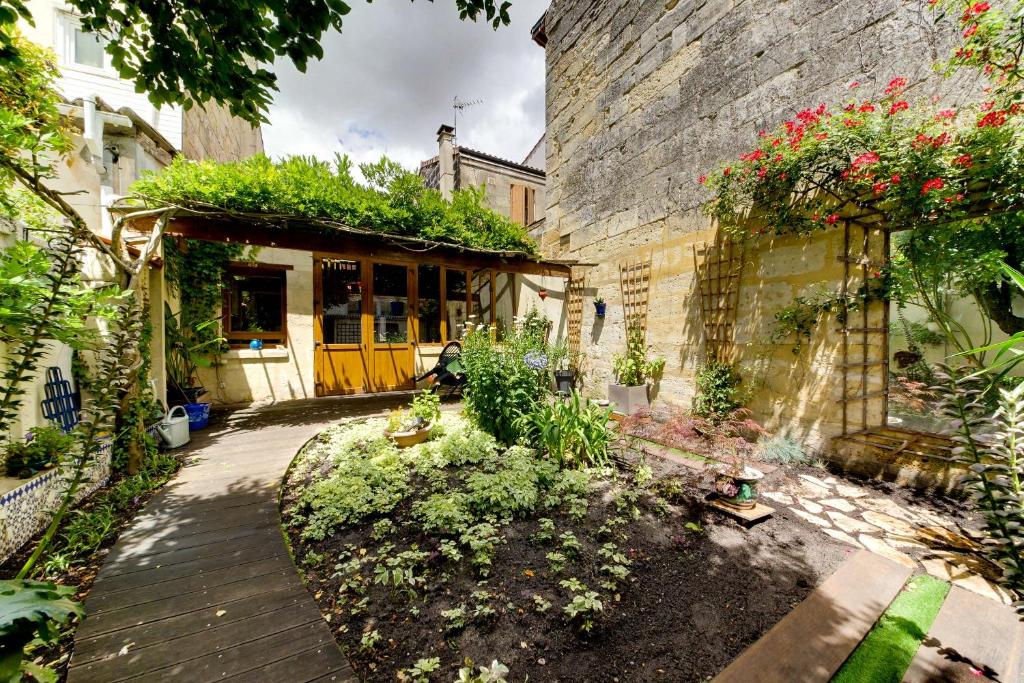 une maison avec une passerelle en bois devant un bâtiment dans l'établissement Superbe maison en pierre bordelaise, à Bordeaux