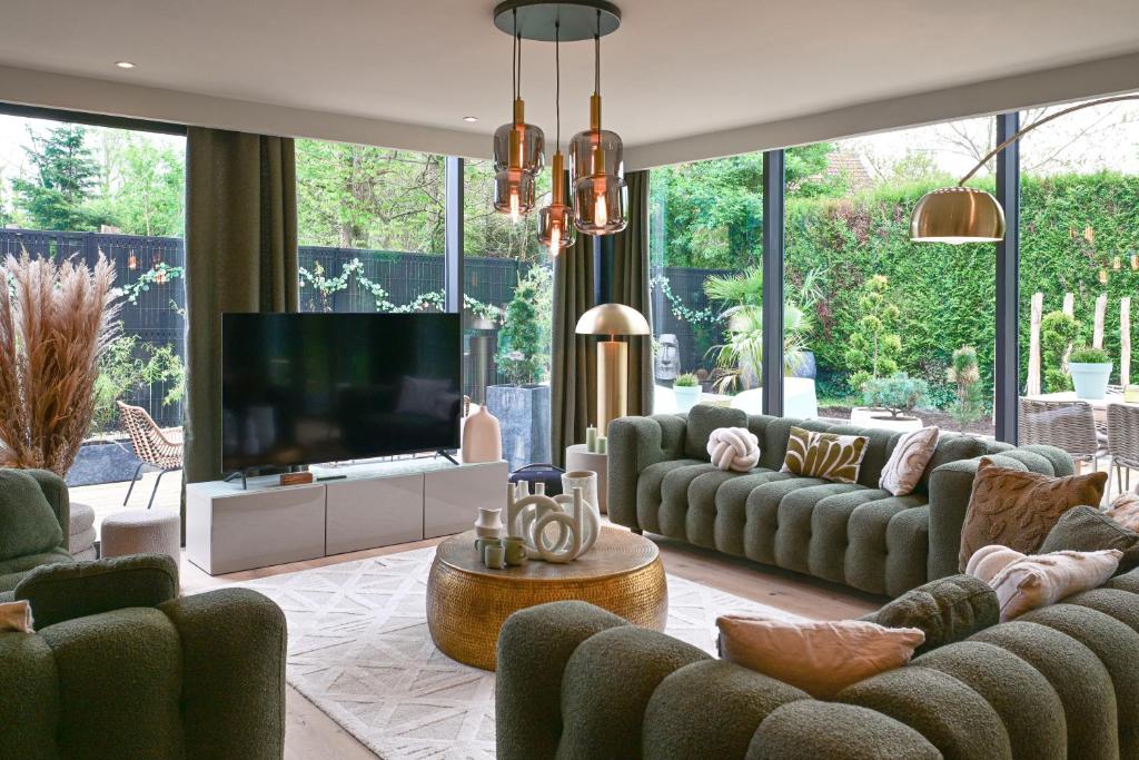 sala de estar con sofás y TV de pantalla plana. en Extraordinaire Villa 5 étoiles 12 personnes 7 min Lille en Marcq-en-Baroeul