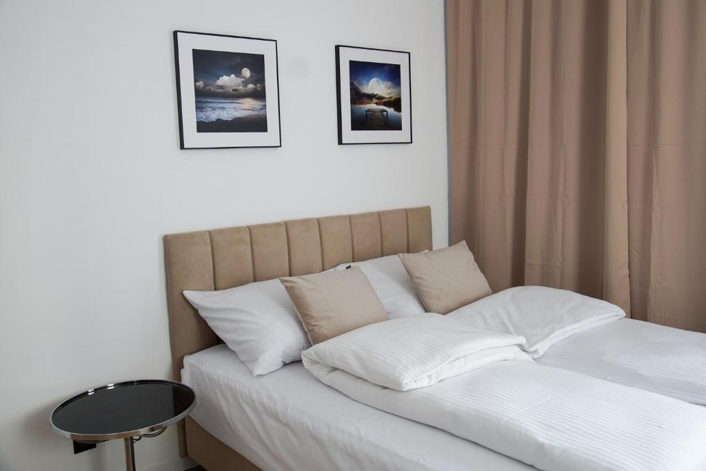 una camera da letto con letto, lenzuola e cuscini bianchi di Toruńska 32 a Chełmno