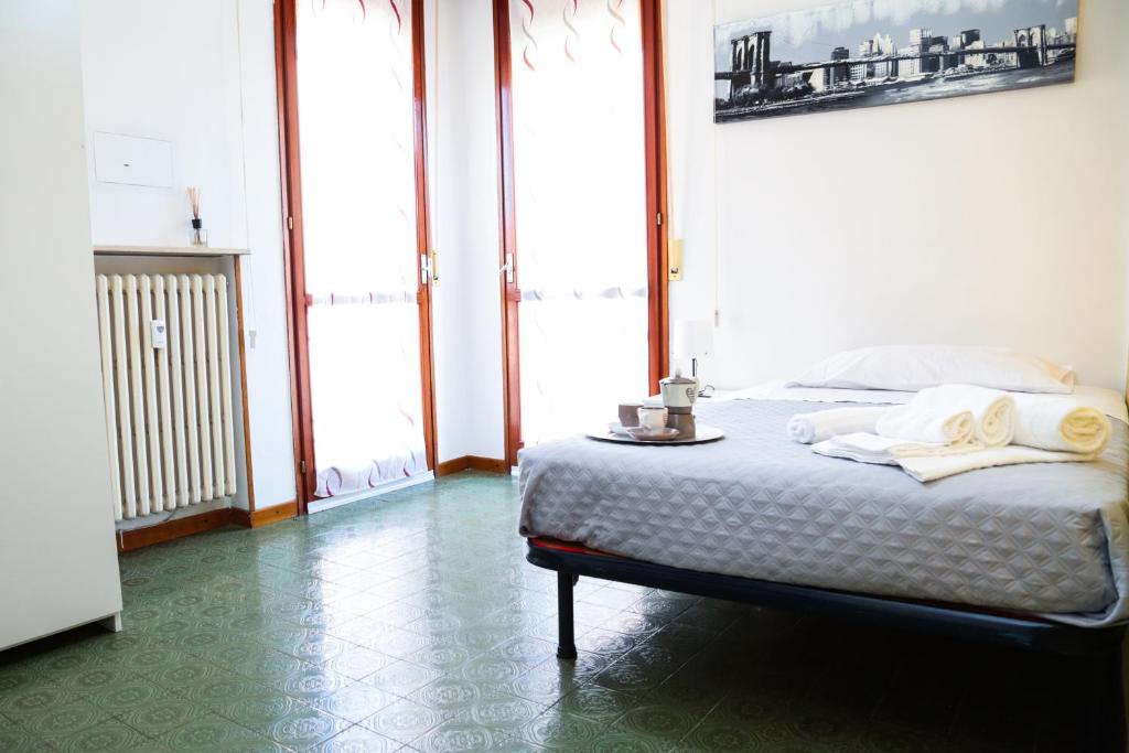 um quarto com uma cama num quarto com janelas em Guest House Gobetti em Reggio Emilia