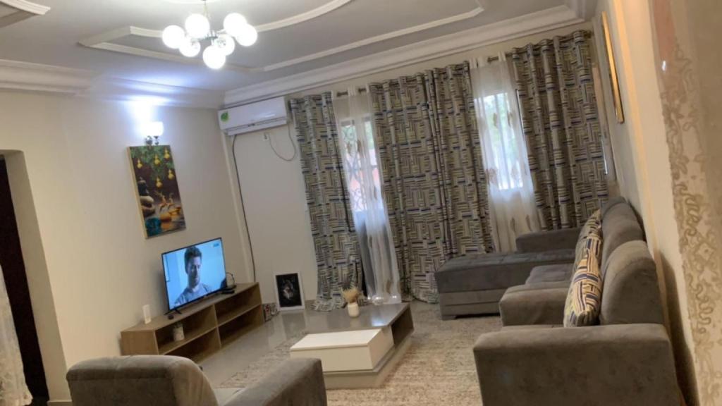 a living room with two couches and a tv at Appartement meublé , Bonamoussadi, Douala-Vanguard's signature Suite in Douala