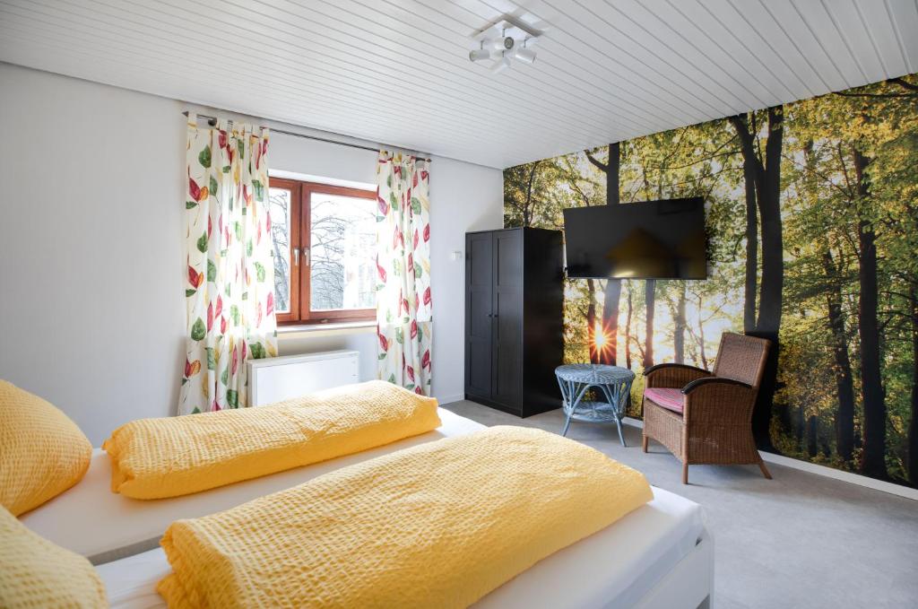 Cette chambre comprend un lit avec des draps jaunes et une télévision. dans l'établissement Wäller Garten, à Westerburg