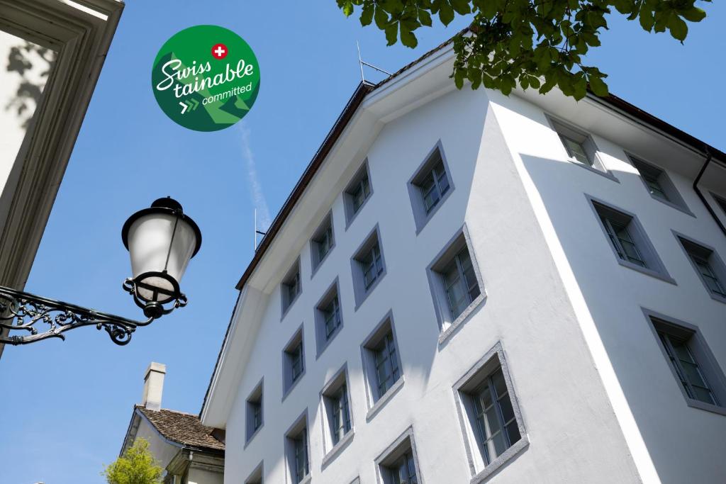 um edifício branco com um cartaz em Boutique Hotel Helmhaus Zürich em Zurique
