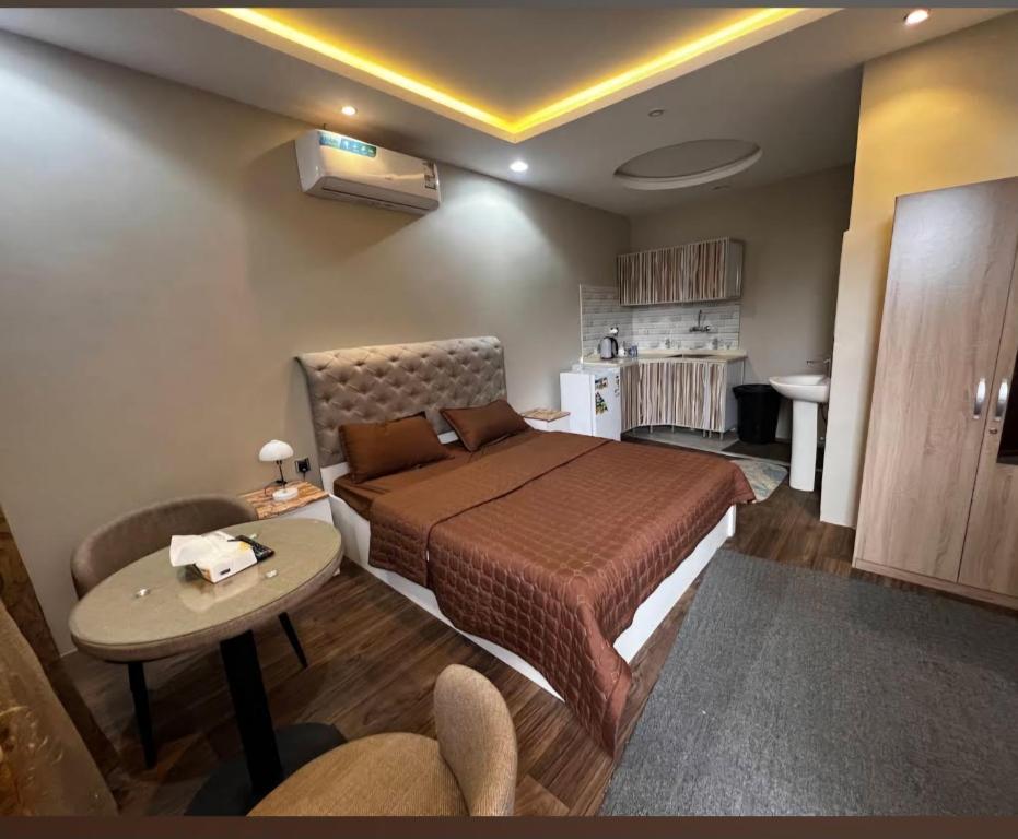 a bedroom with a bed and a table in a room at استوديو ريفي تنومه in Tanomah