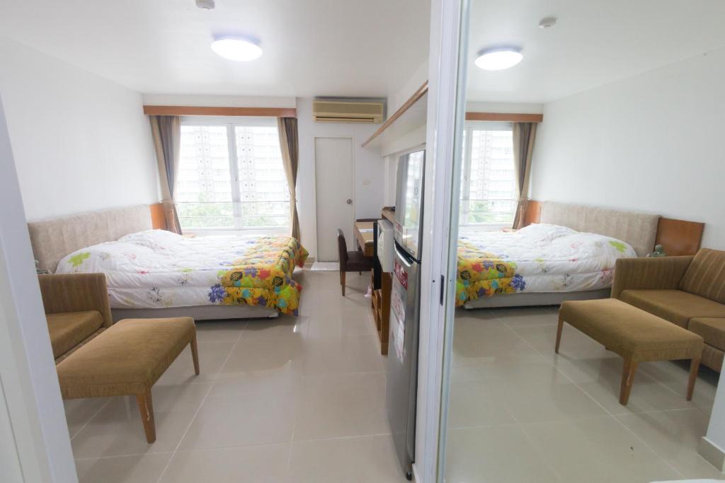 a bedroom with two beds and a table and chairs at Condo I -House Laguna Garden RCA - Outer CBD in Bangkok