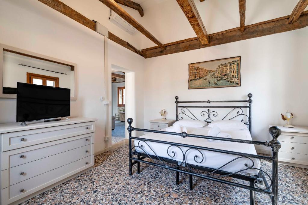 a bedroom with a bed and a flat screen tv at Ca' Canciani in Venice