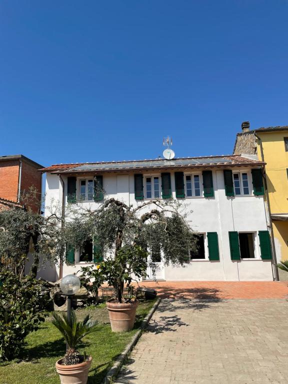 a large white building with trees in front of it at Casa vacanze Eny in Capannori