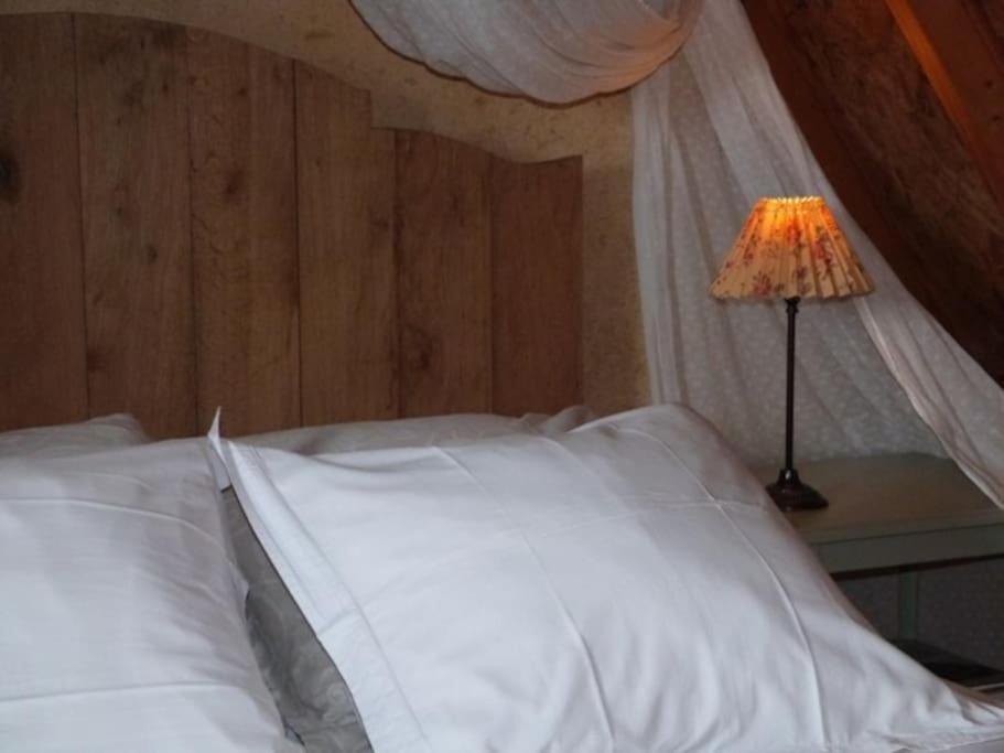 Giường trong phòng chung tại La chaumière *cocoon* de la Fontaine blanche