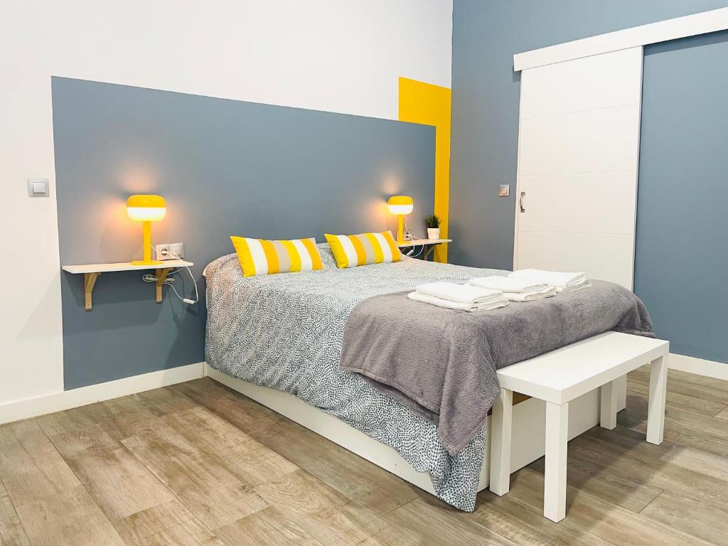 een slaapkamer met een bed met geel en blauw bij Moderno y bien situado P8 in Málaga