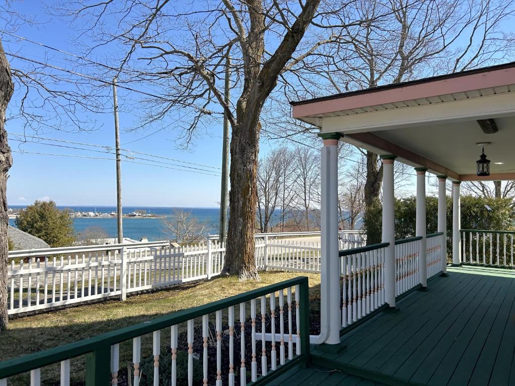 a porch of a house with a white fence at Lady Mary Angeline in Saint Ignace
